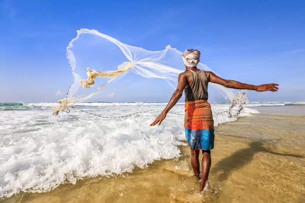 Sri Lankan fisherman throwing a fishing net in the sea