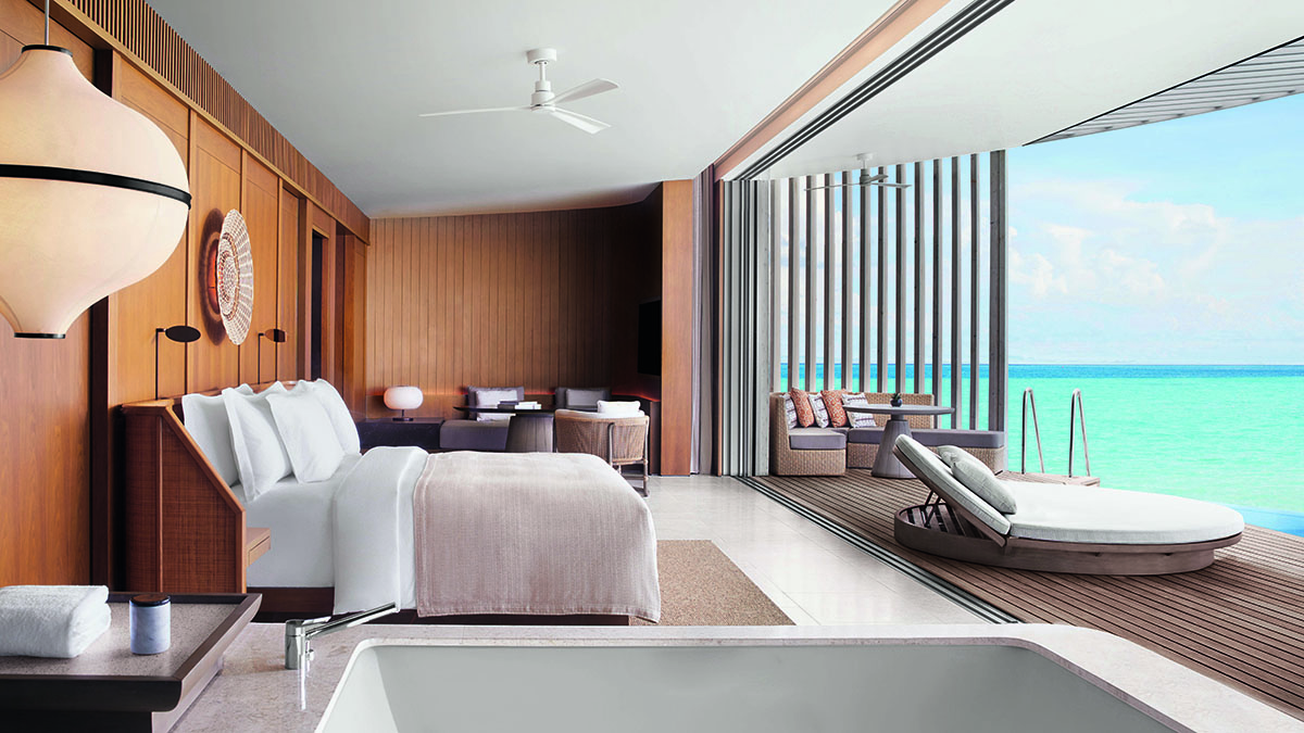 A a white and light brown bedroom with a bath overlooking the sea