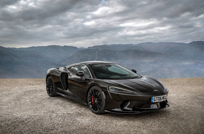 A black McLaren GT on top of a mountain
