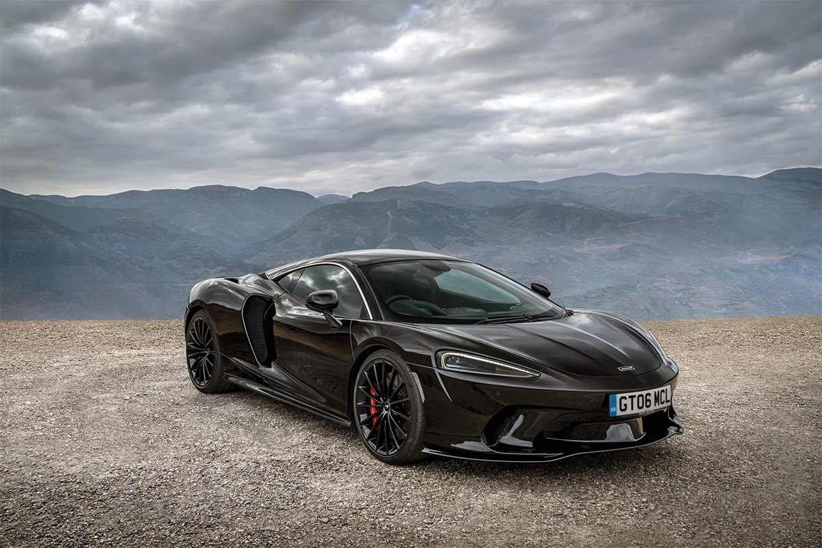 A black McLaren GT on top of a mountain