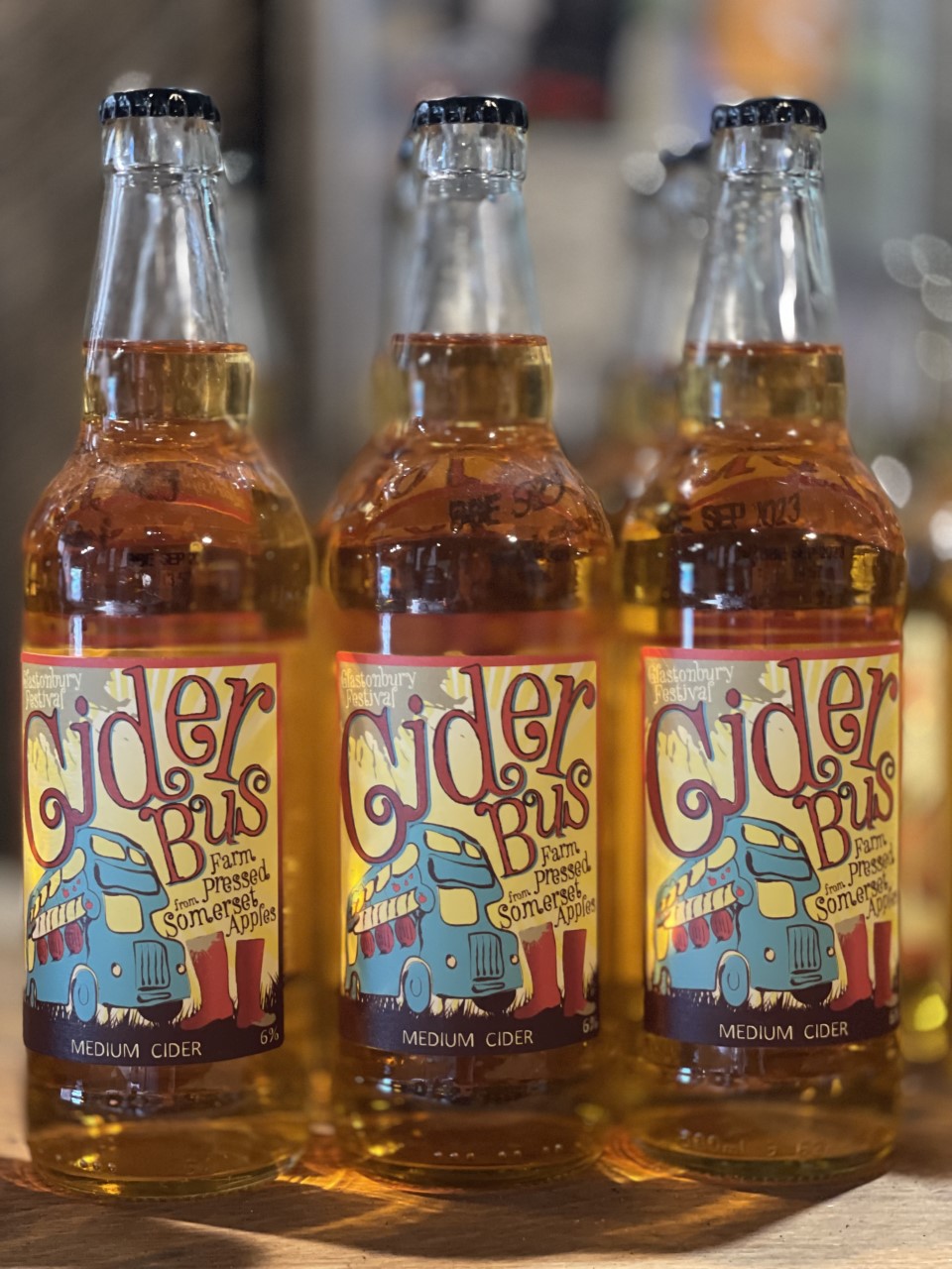 Three bottles of cider with a yellow and blue and label with red writing