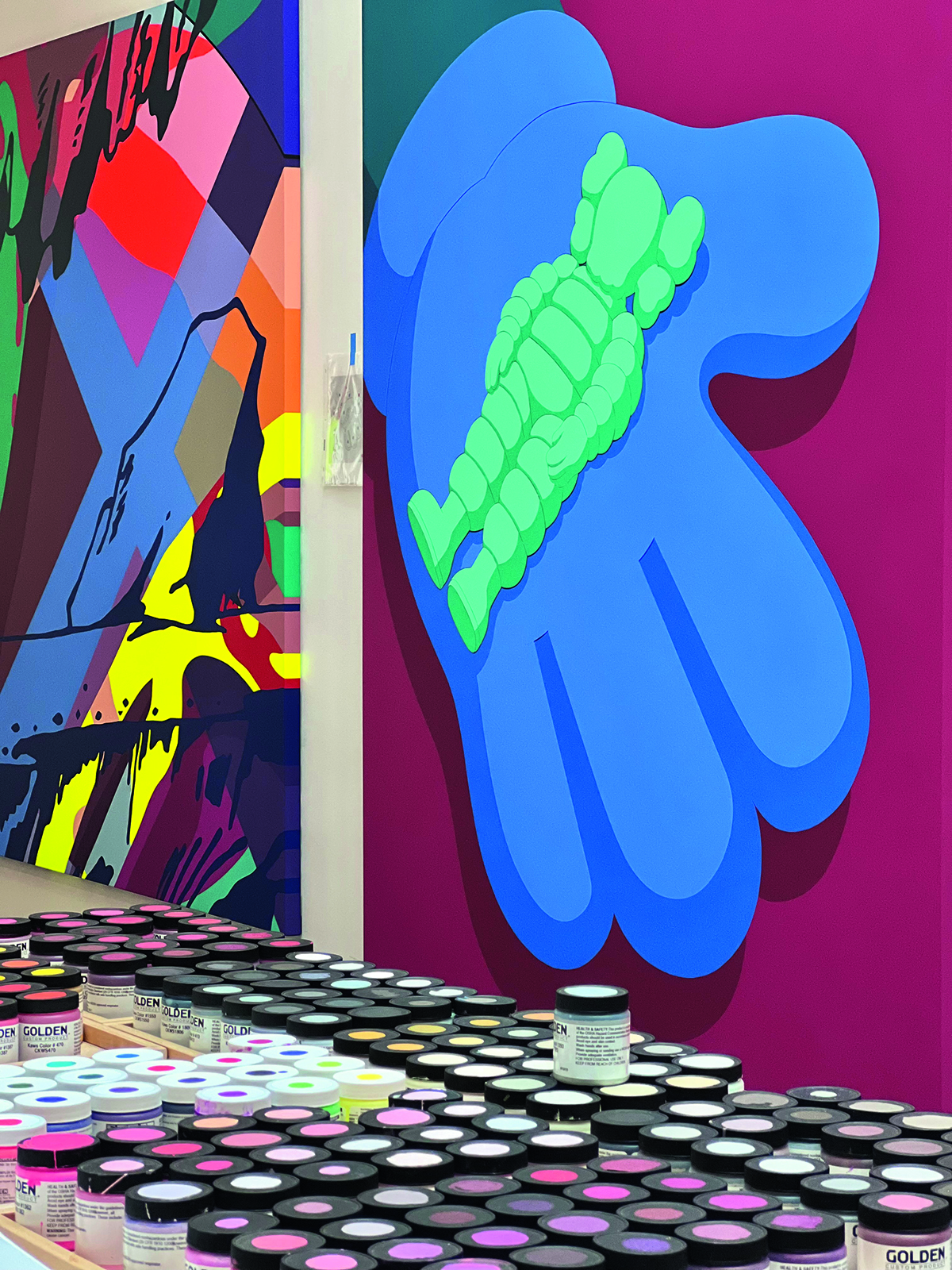 A colourful painting of a blue hand on a pink wall