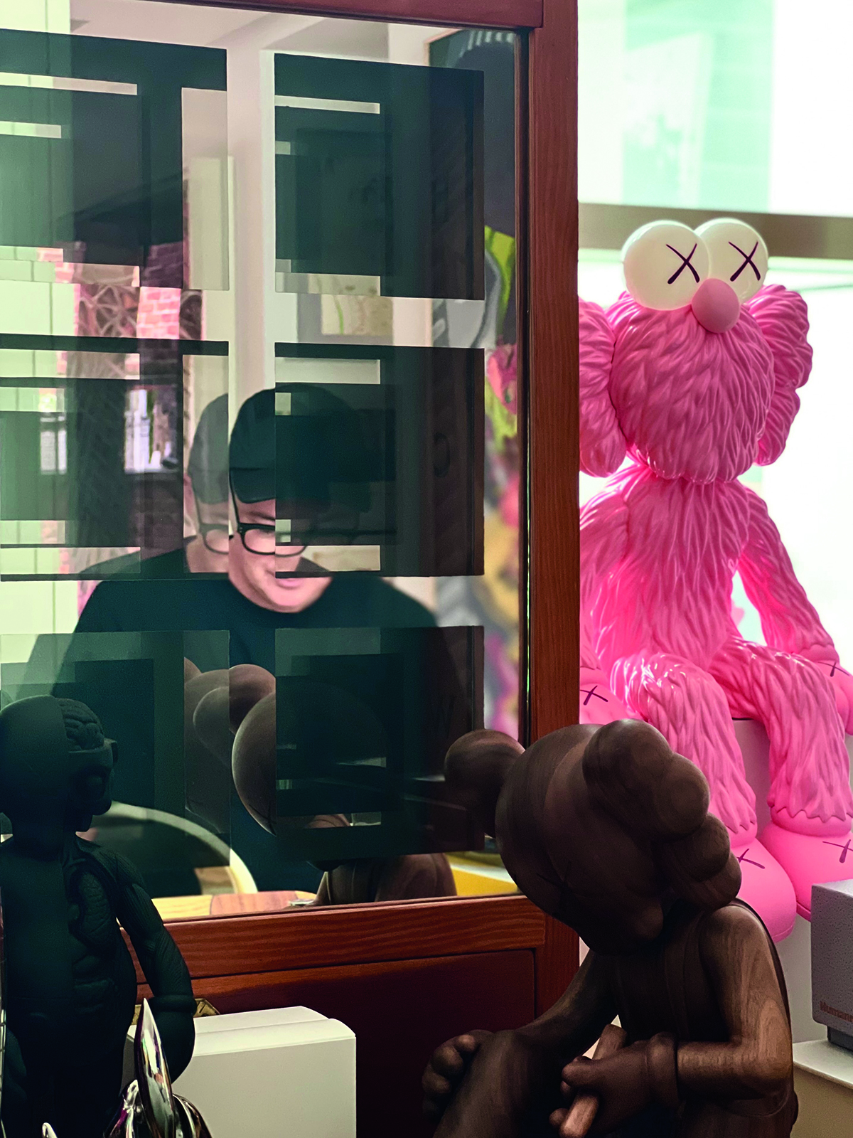 A large pink fluffy toy elephant with big white eyes sitting on a window sill