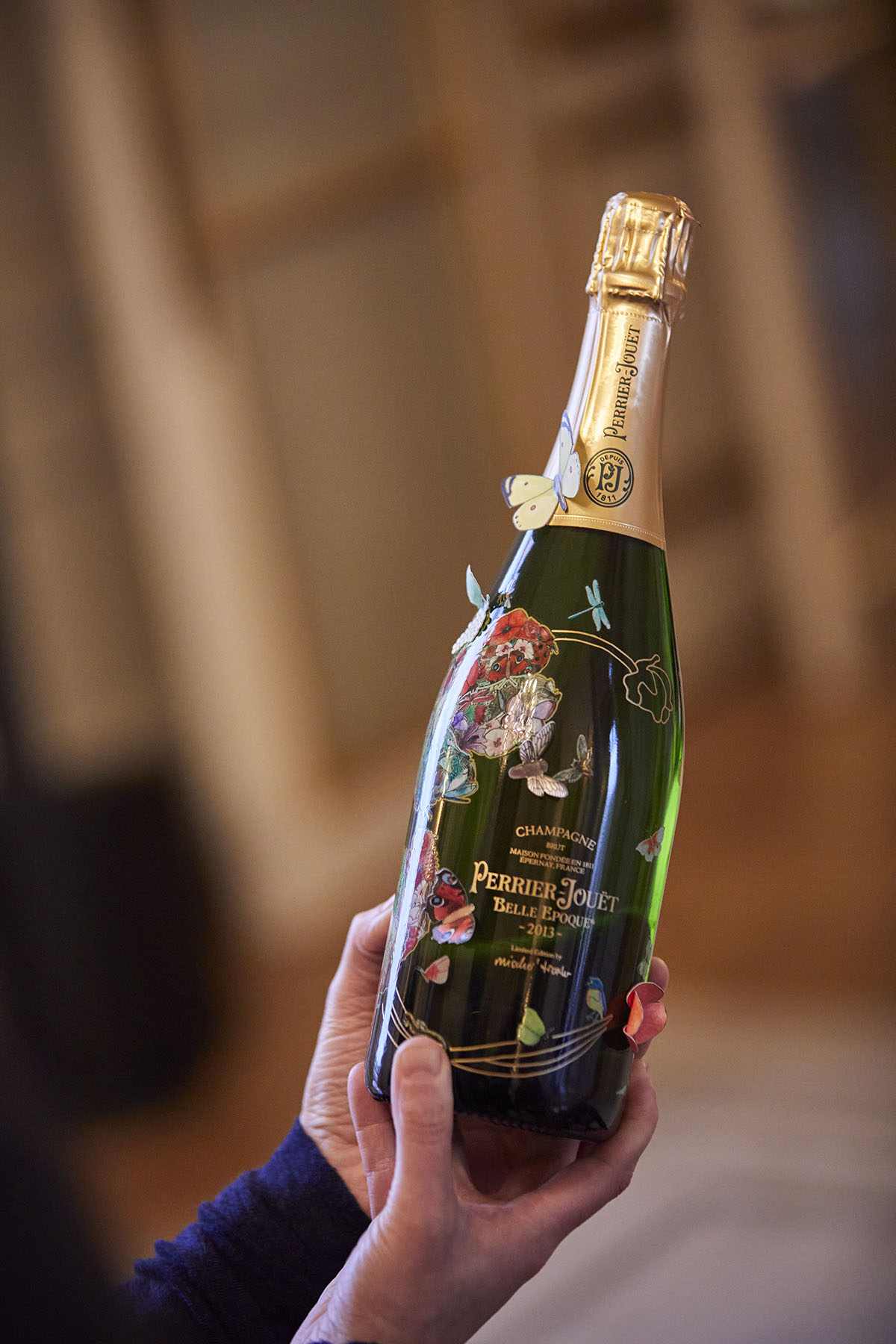A bottle of champagne with flowers and butterflies on it