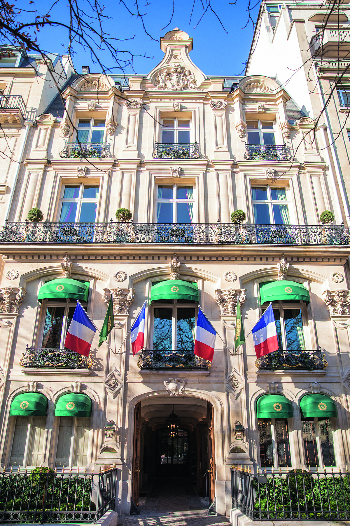 The exterior of a Parisian building with green awnings 