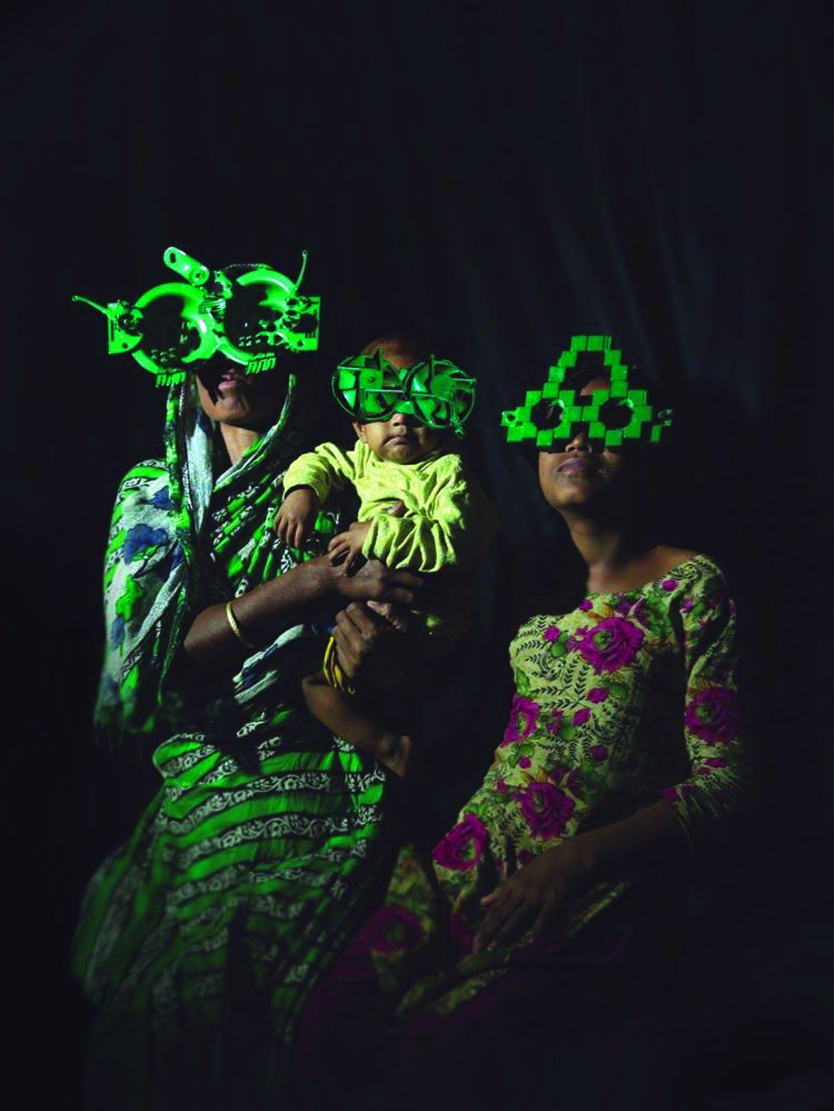 Two women and a baby wearing large green glasses