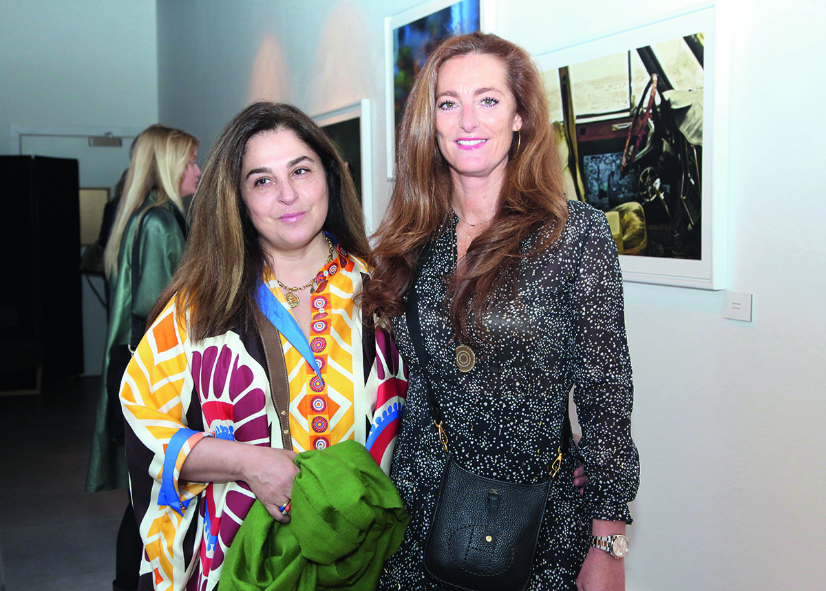 A woman in a multicoloured top standing next to a woman in a grey dress