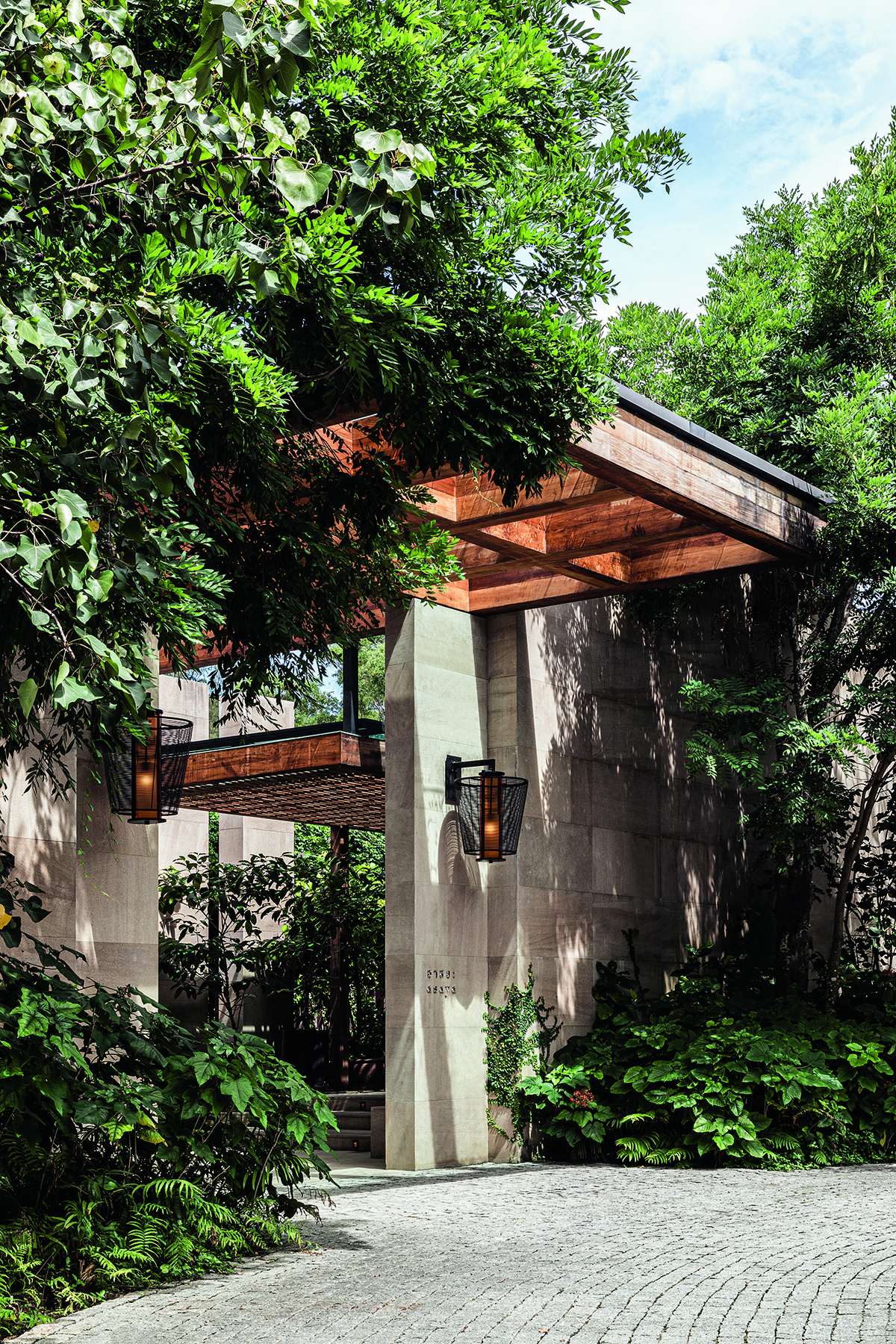 An entrance with white stone and trees