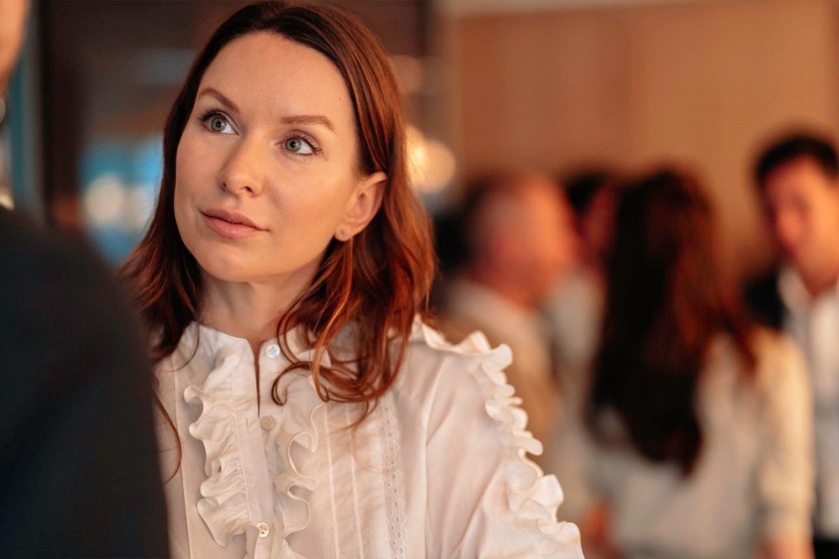 A woman with red hair wearing a white shirt