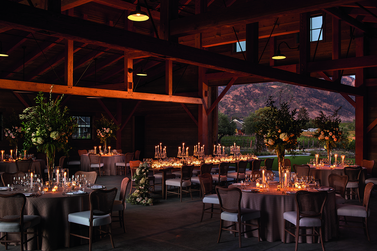 barn-style room with tables, chairs, candles