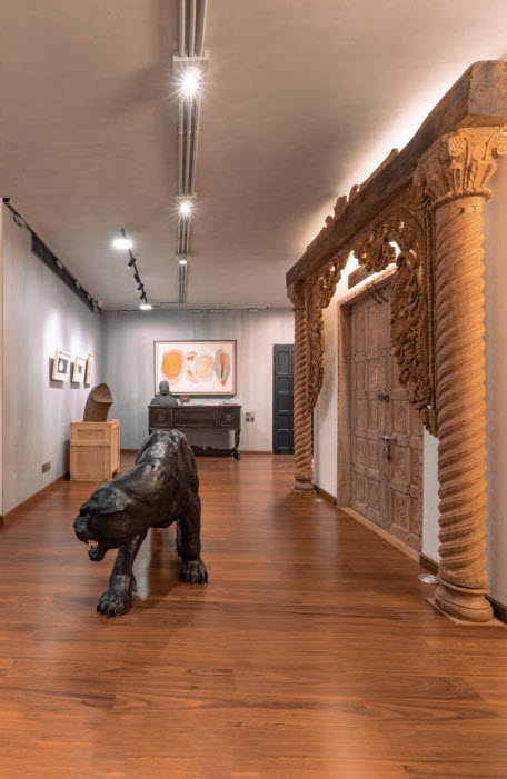 A sculpture of a lion walking in a wooden room