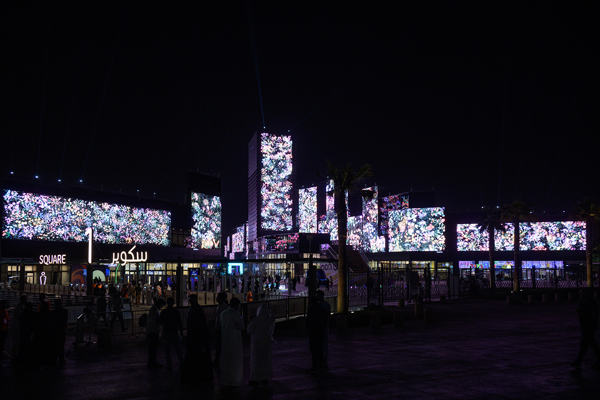 flower artwork on screens in a city