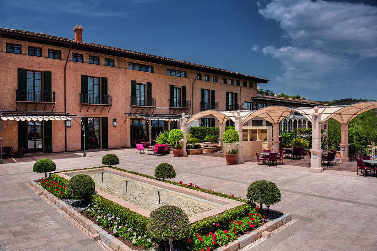 A large terrace outside a yellow stone building