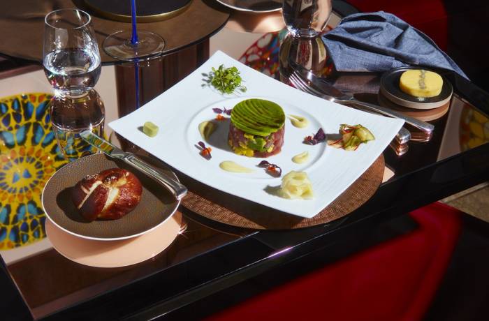 a white plate with a tuna tartar and a leaf on the top