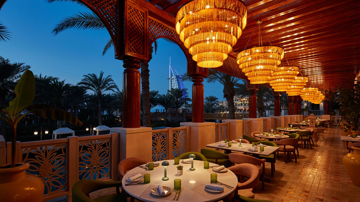 A restaurant on a terrace with palm trees around