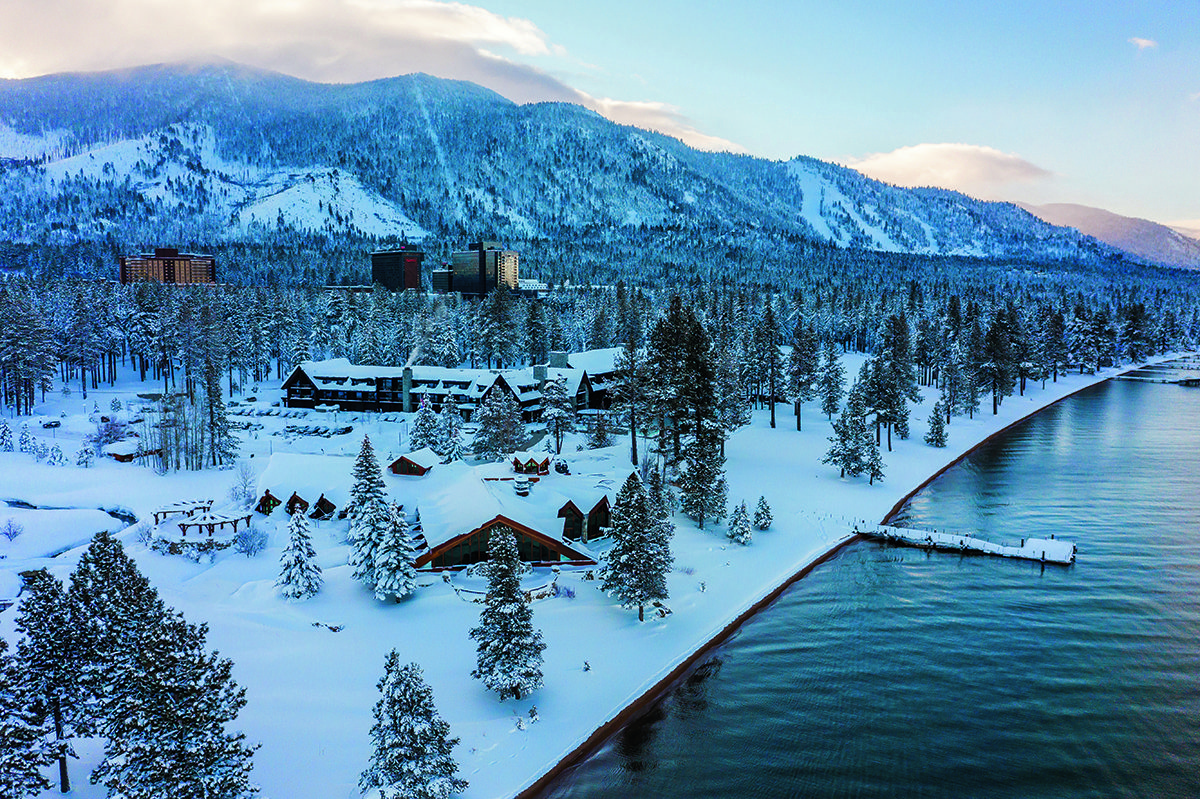 A mountain and hotel on a lake covered in snow