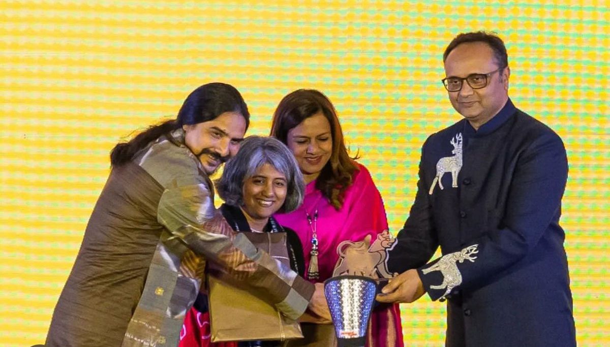 Two men and two women standing around an award