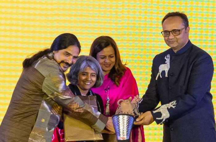 Two men and two women standing around an award