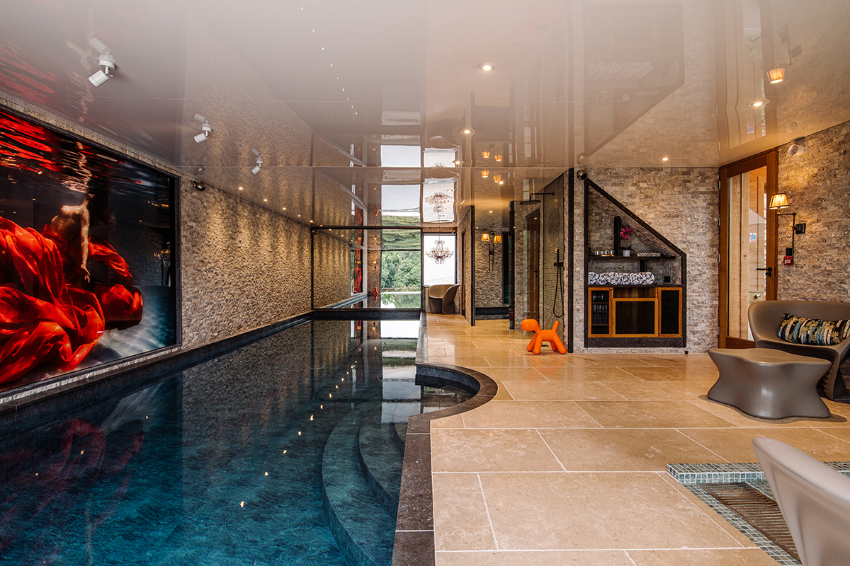 A swimming pool with an orange dog sculpture in the corner of the room