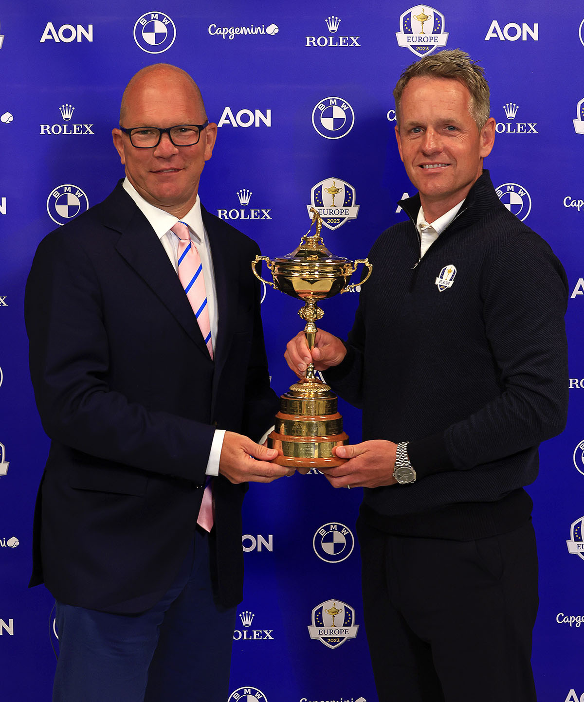 Two men holding a goldtrophy