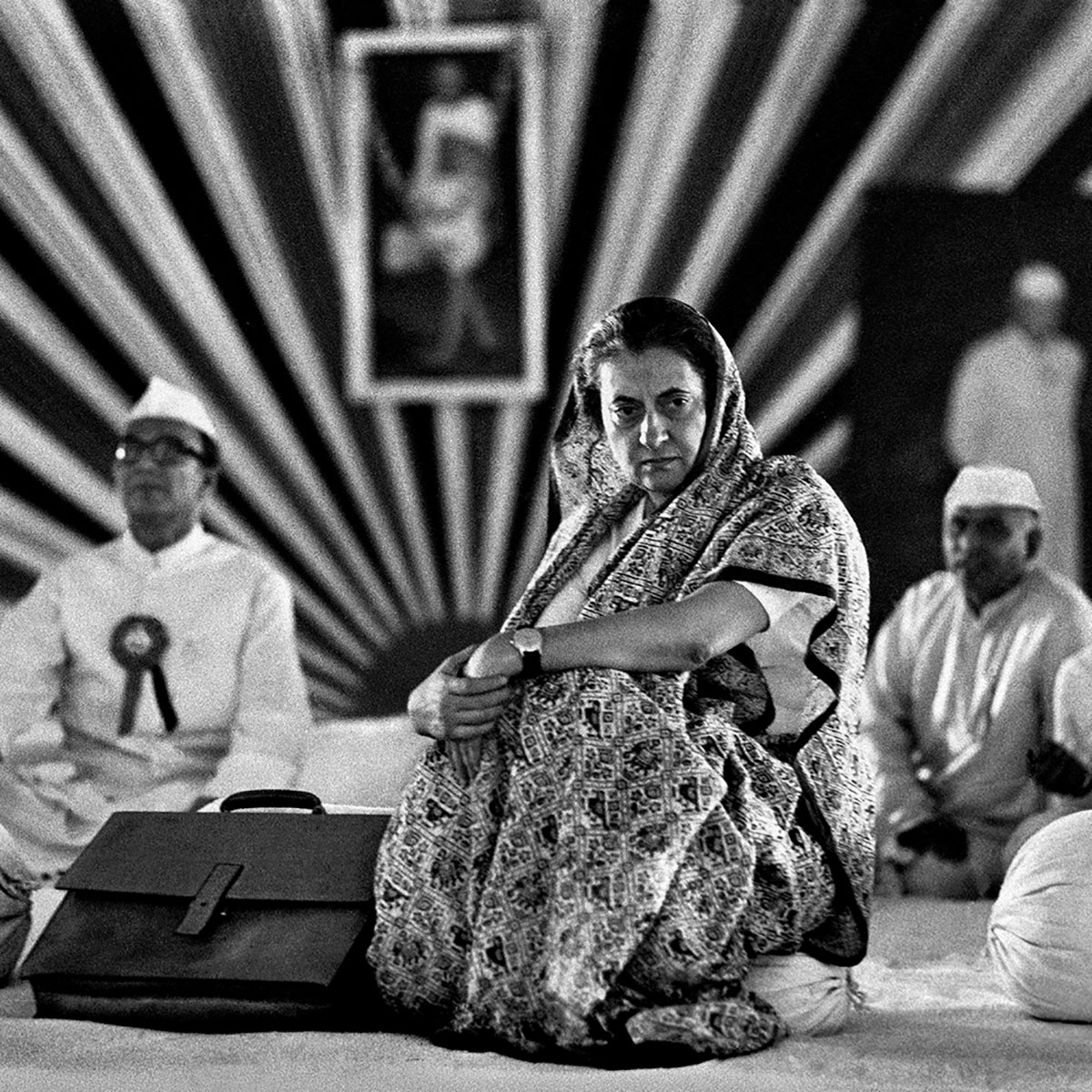 A woman sitting on a floor in a striped tent