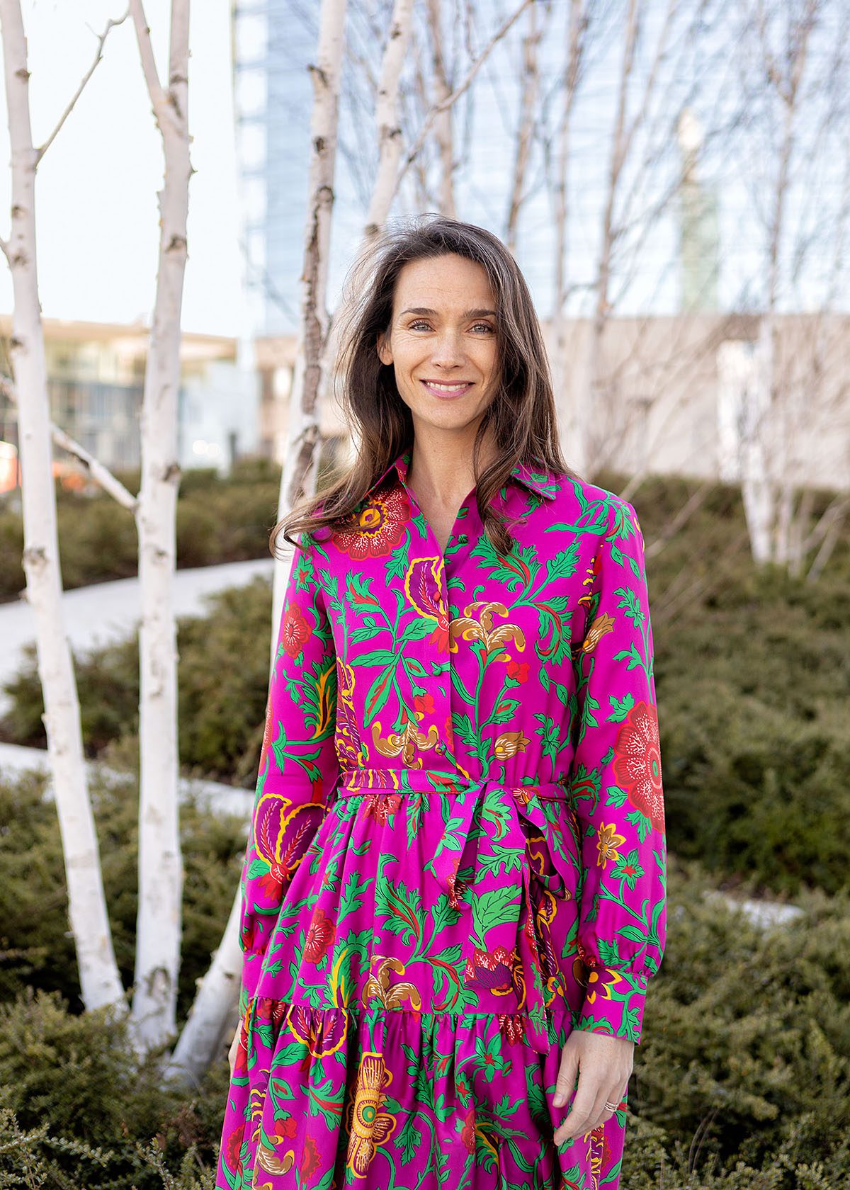 A woman with brown hair wearing a pink dress