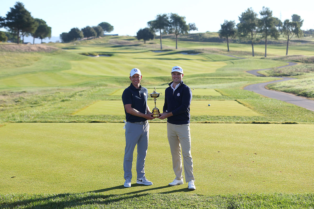 Two men holding a trophy on a golf course