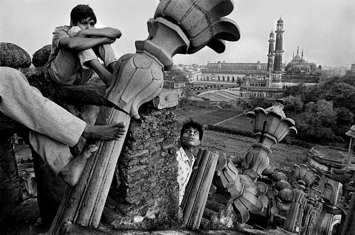 Some children sitting amongst ruins in a city