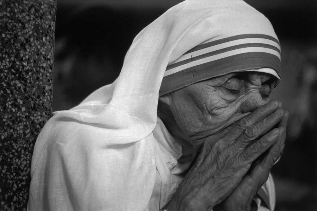 Mother Teresa putting her hands to her mouth in prayer