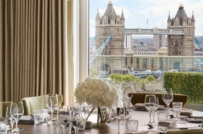 A dining room with a window view of Tower Bridge