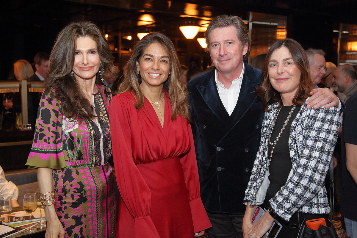 three women standing with a man for a photograph