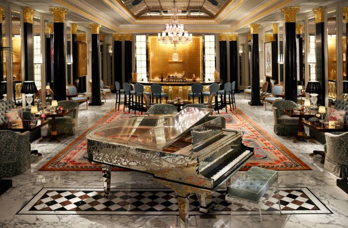 A silver piano in a bar with black and gold interiors