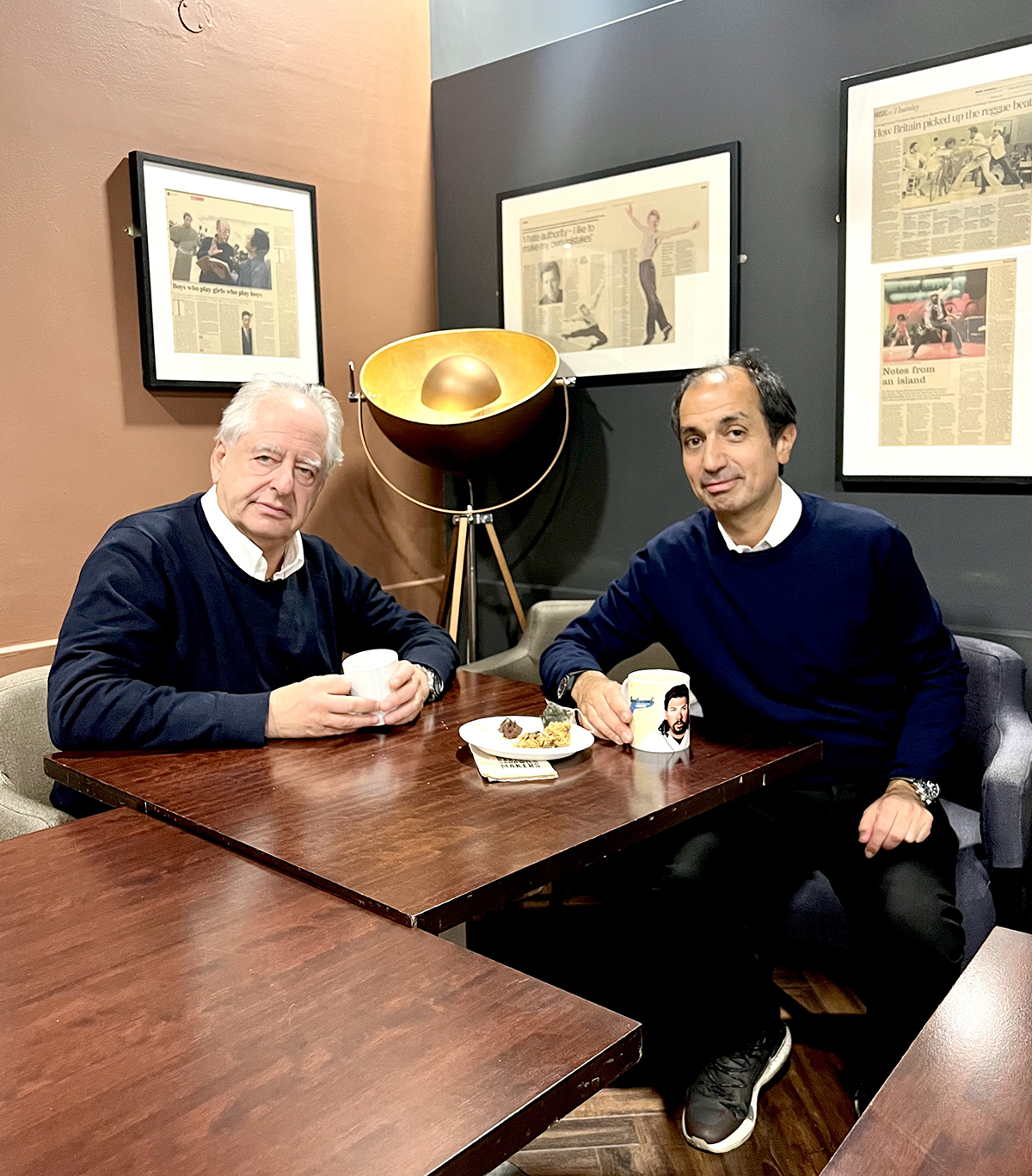 two men having coffee at a wooden table