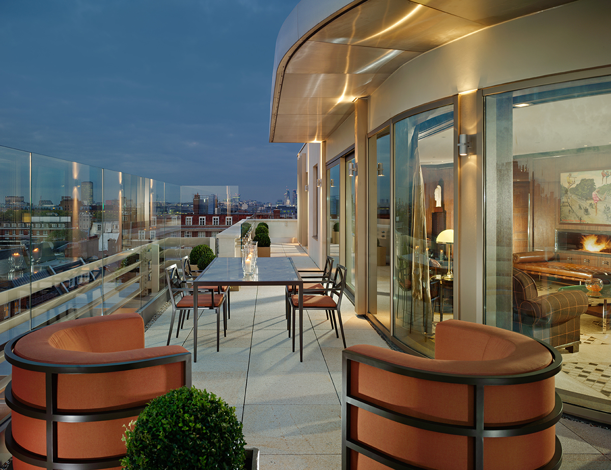 A balcony with red and wooden chairs overlooking London