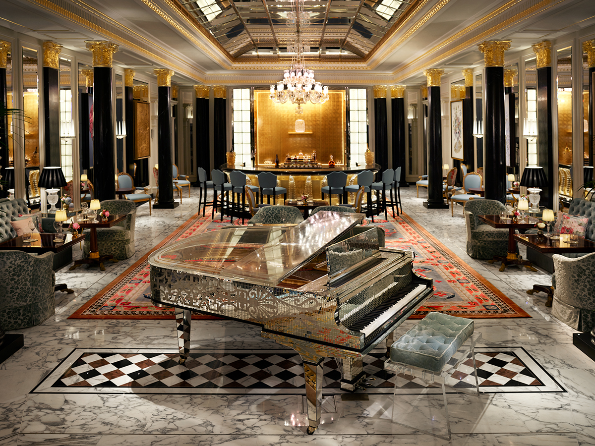 A silver piano in a bar with black and gold interiors