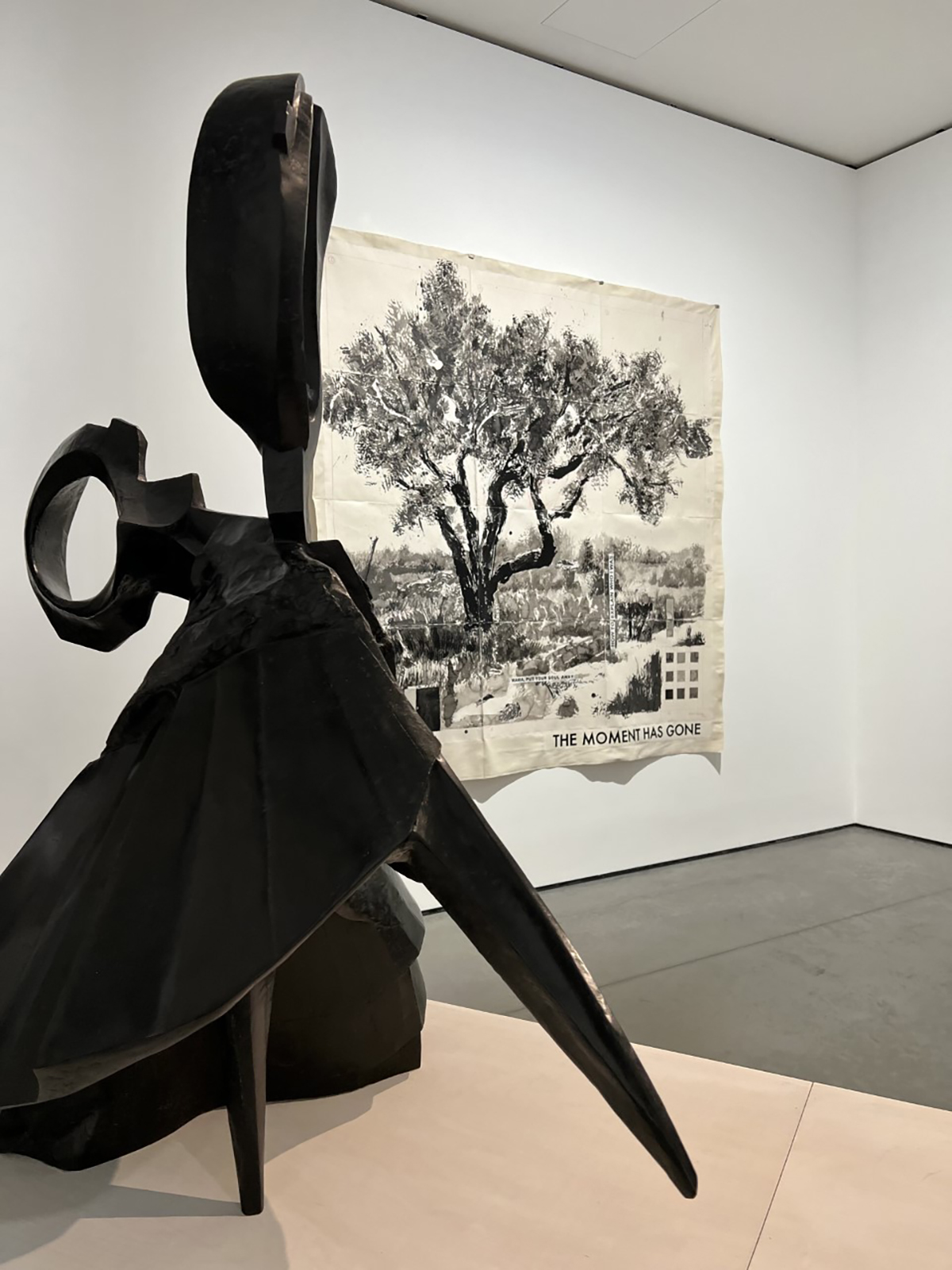 A painting of a tree with a sculpture in front of it
