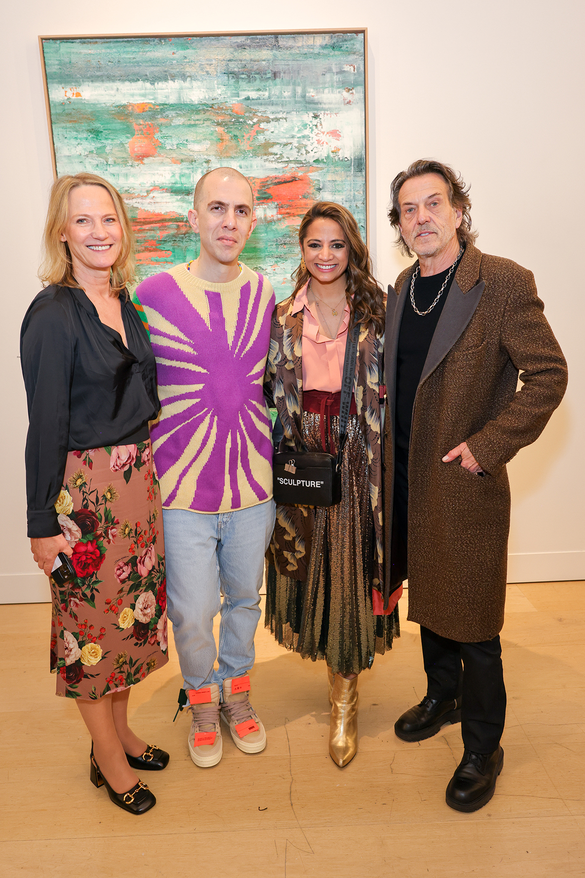 A woman wearing a floral skirt standing next to a man wearing a purple jumper and orange trainers next a woman and man wearing brown and pink clothes