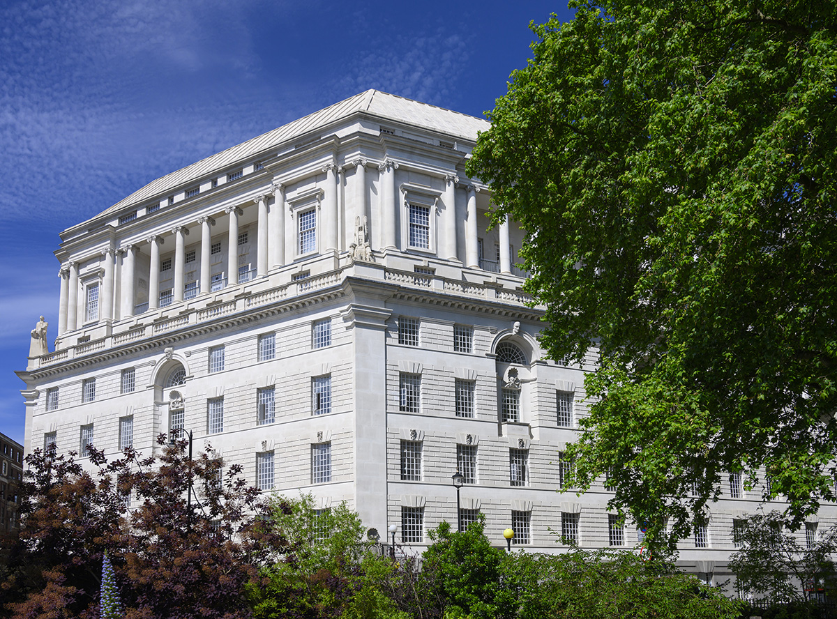 A white building with a tree in front of it