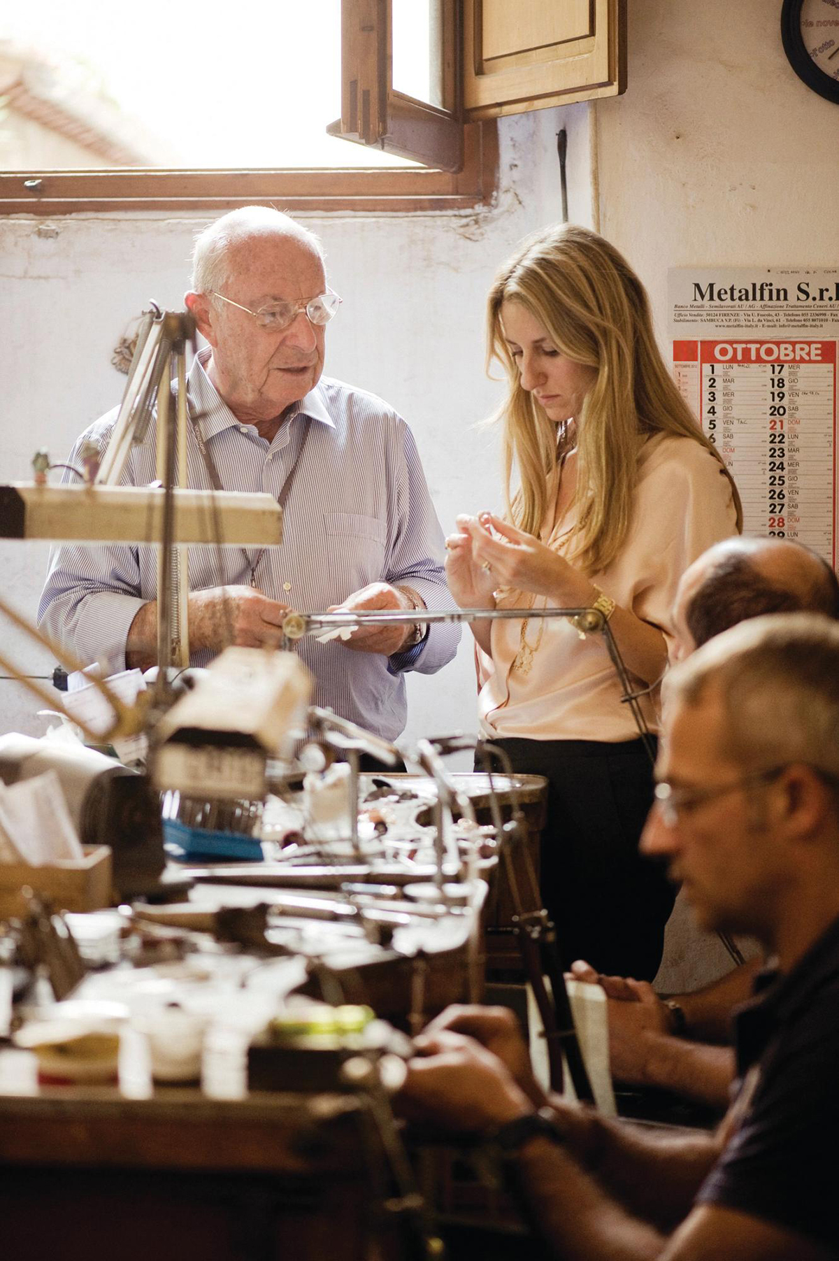A woman working with an older man in a workshop