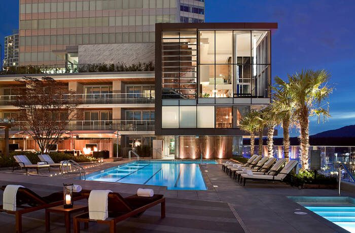 A pool outside a lit up building at night