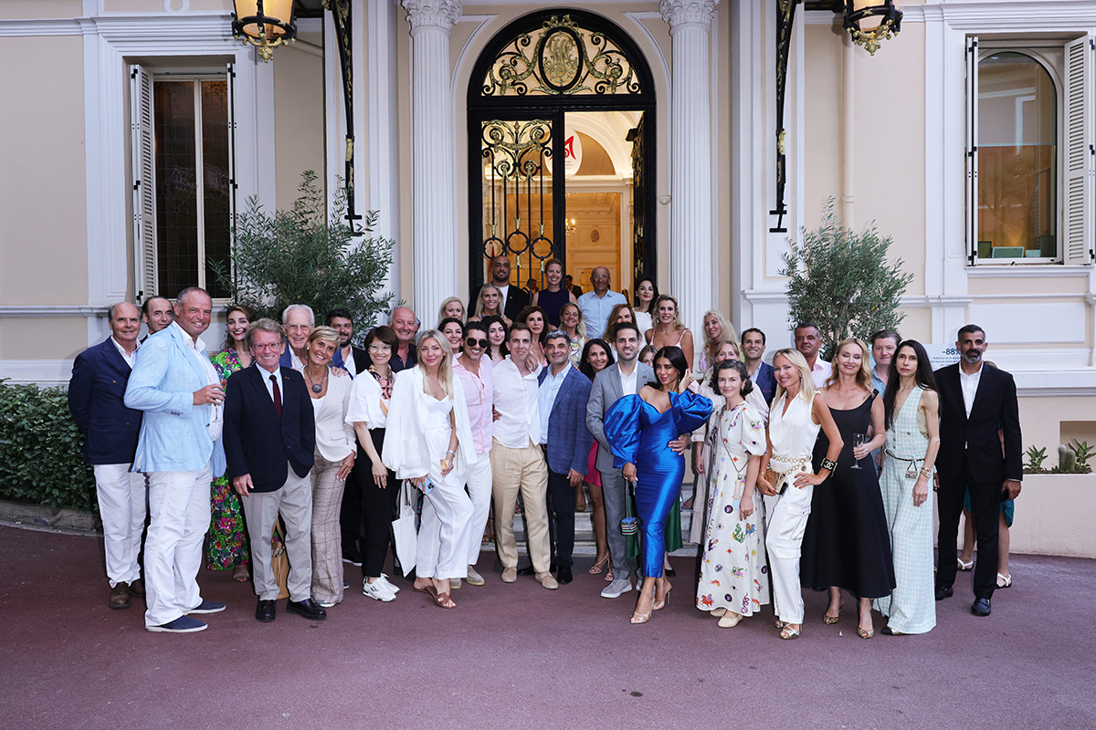 A group of people standing outside an entrance arch into a buildng