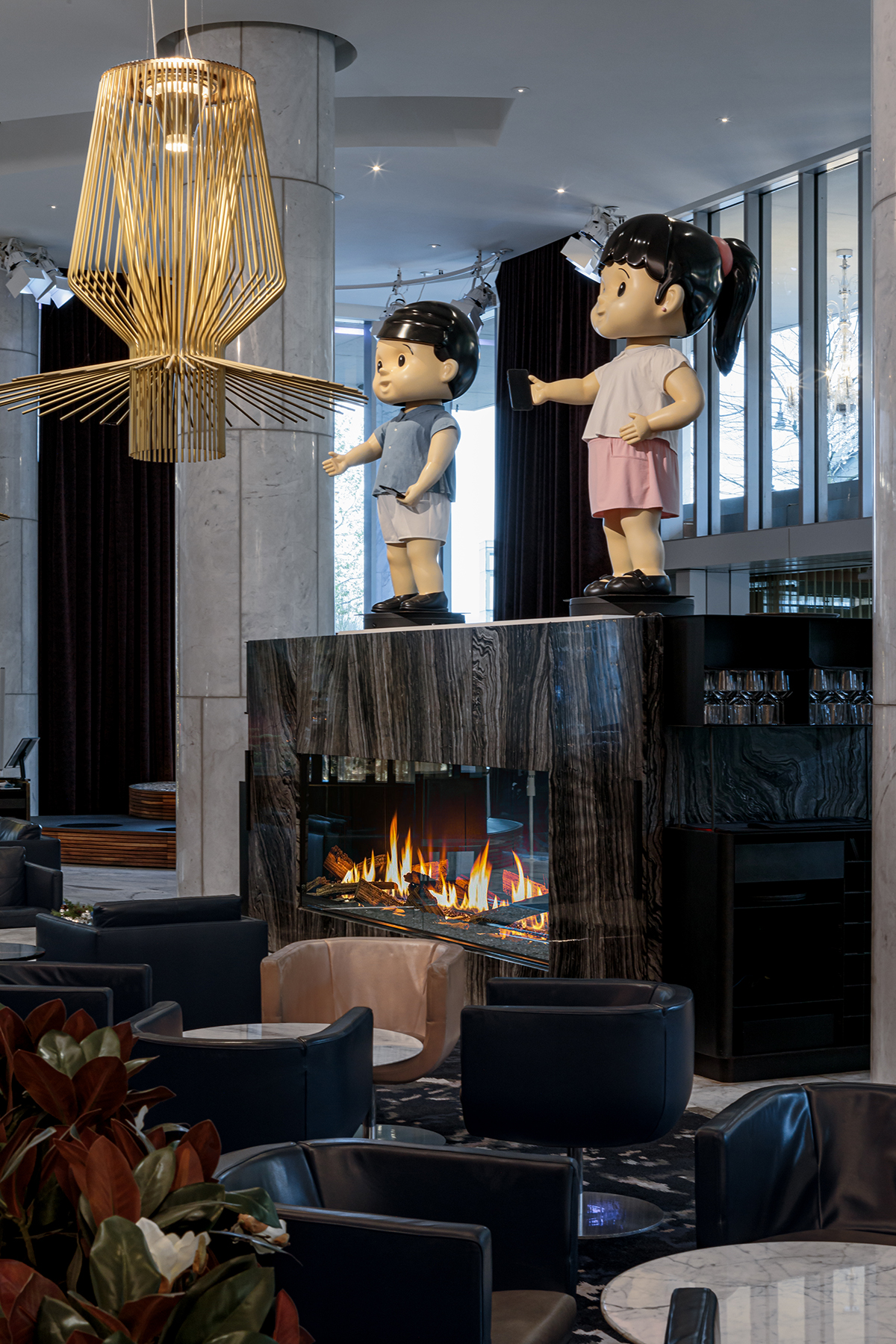 A fireplace with large sculptures of children on top of it
