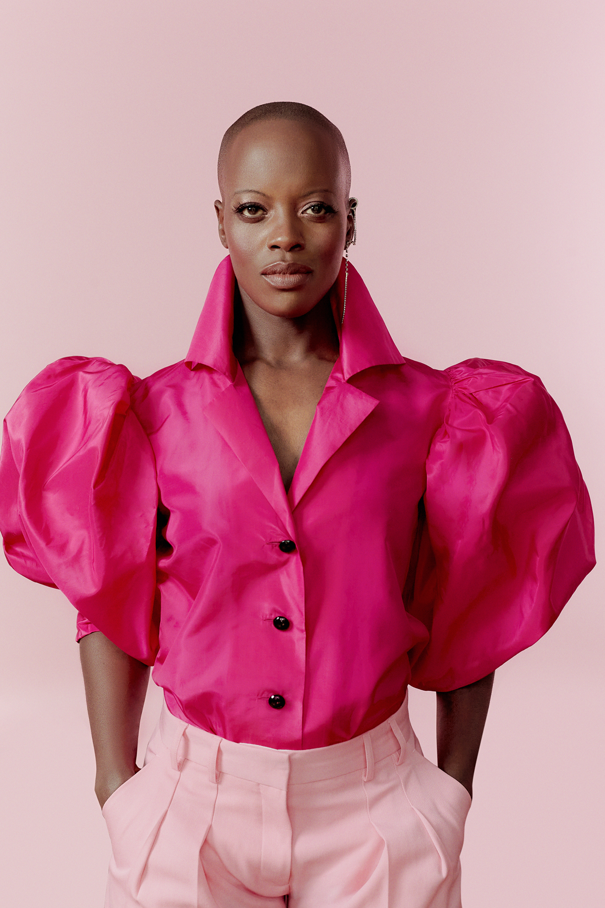 A woman wearing a pink shirt with puffy sleeves and light pink trousers