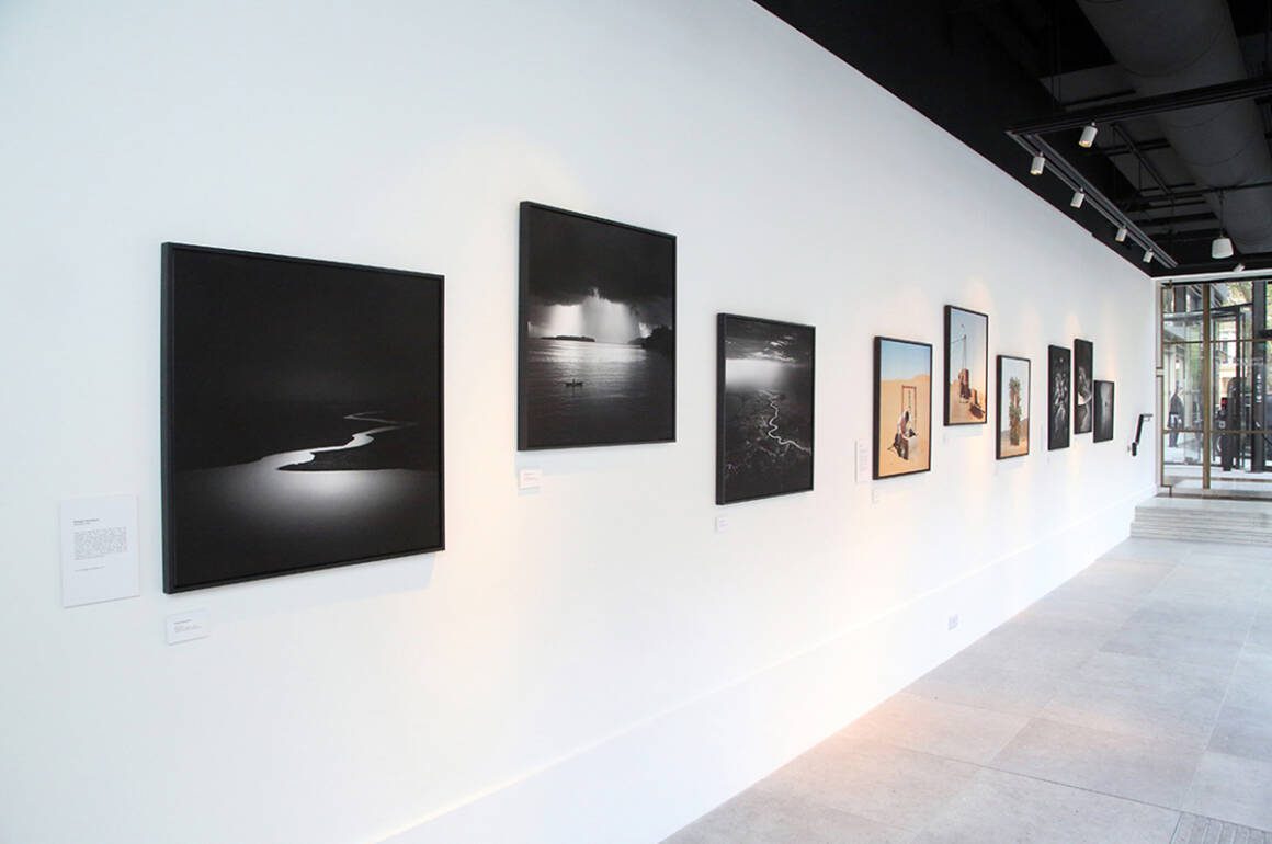 A white wall with photographs along it