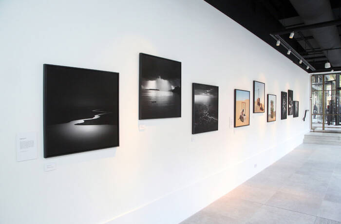 A white wall with photographs along it