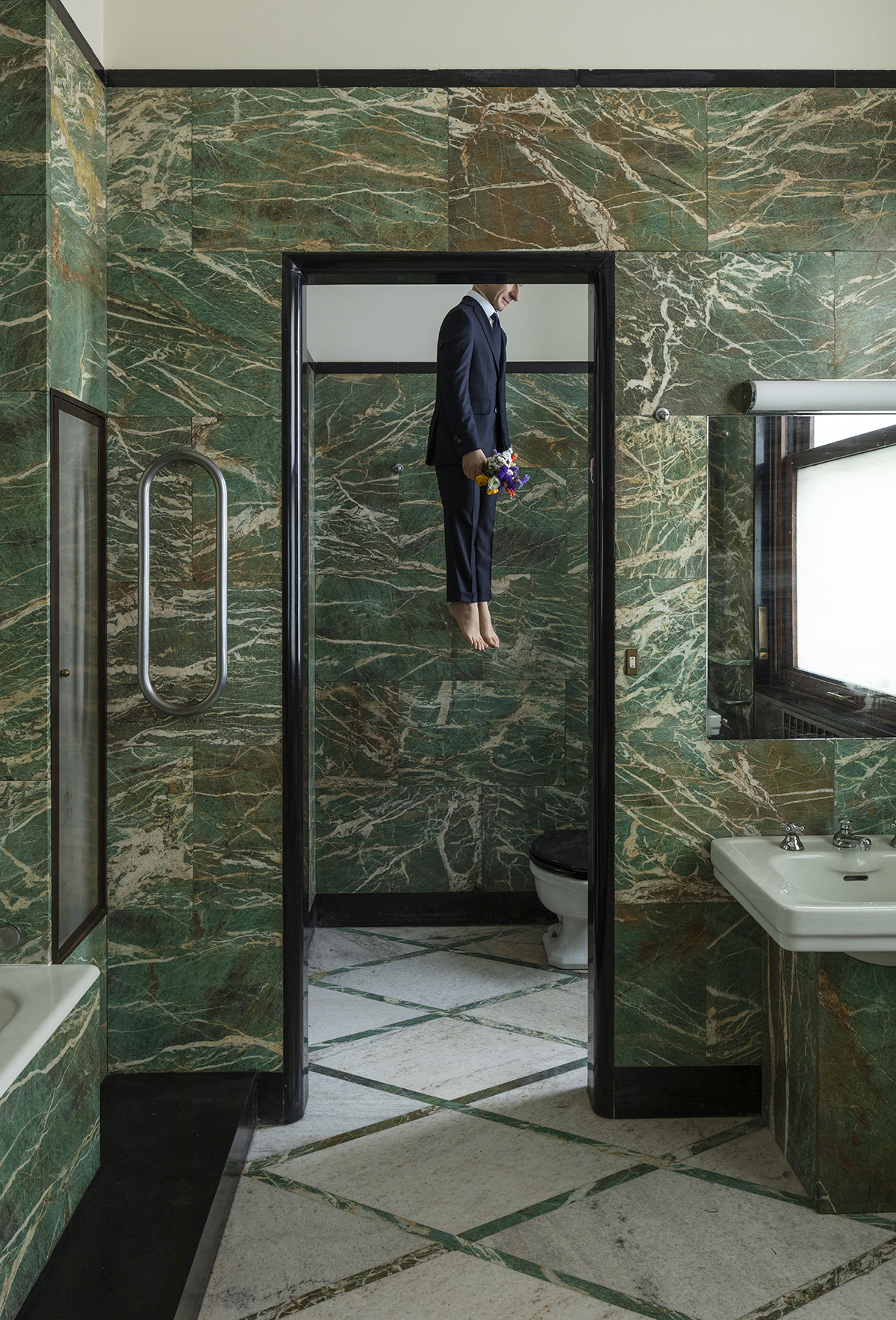 A man hanging from a green bathroom