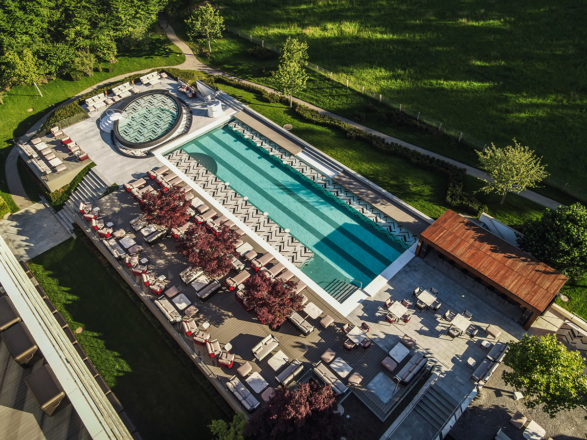 A swimming pool surrounded by chairs and grass