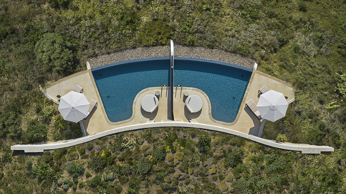 A pool surrounded by grass from a bird's eye view