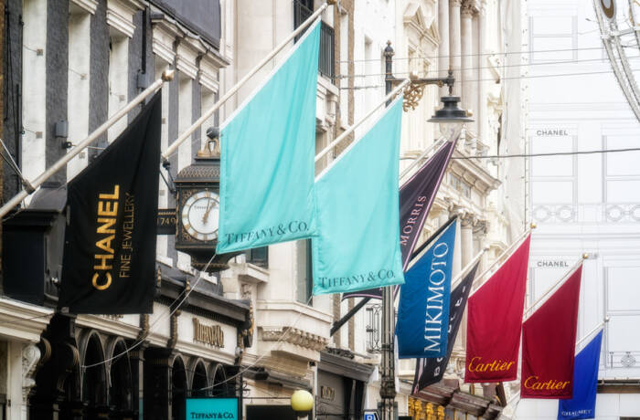 shops with brand flags over the entrances on bond street