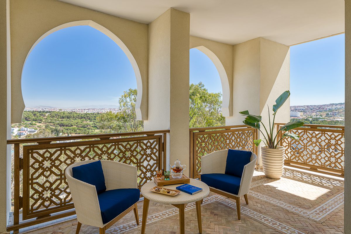 A terrace with arched walls and blue and white chairs